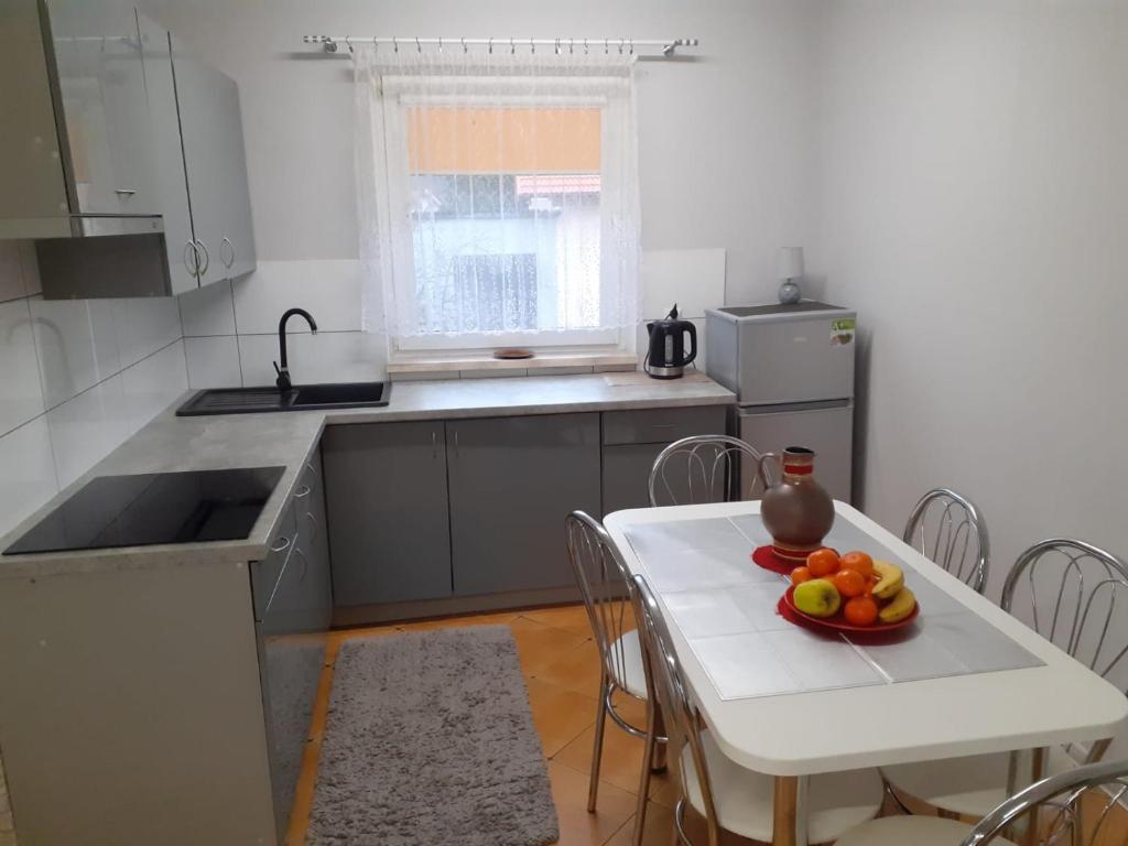 a kitchen with a table with a bowl of fruit on it at Mazurskie Wzgórze Apartament in Rydzewo