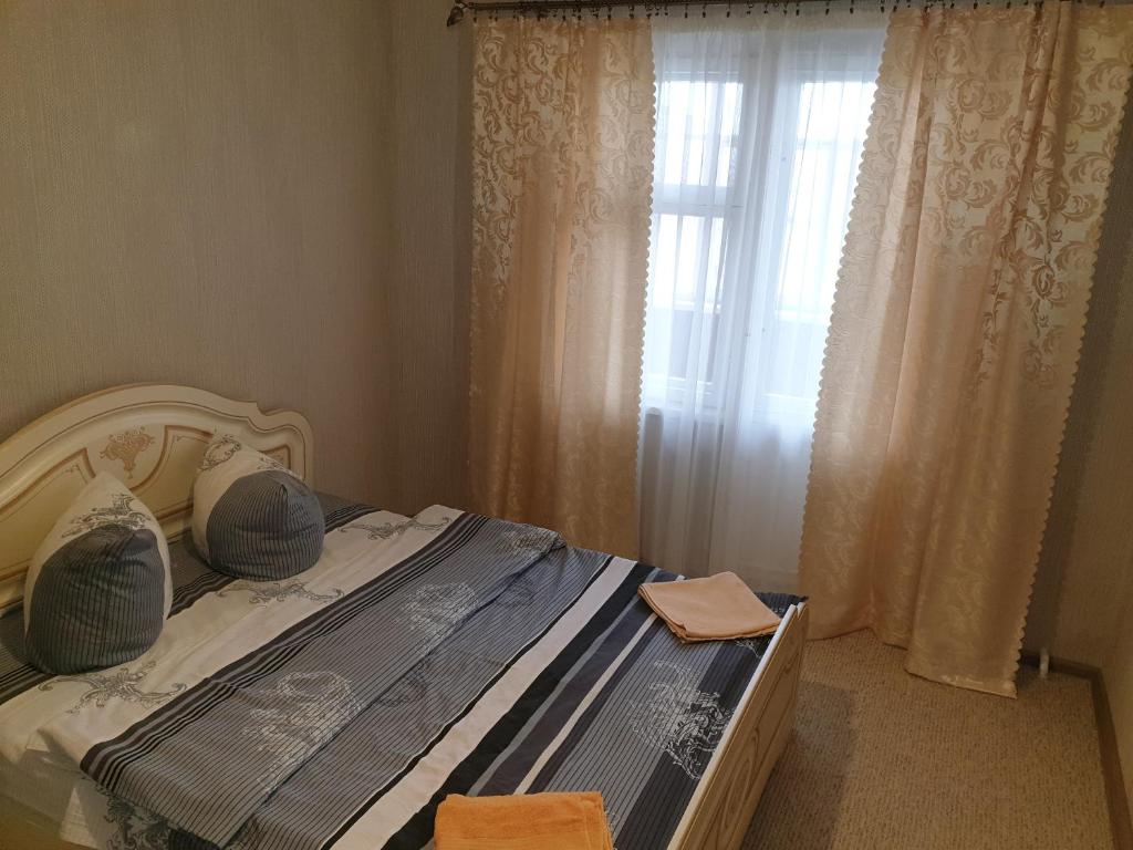 1 dormitorio con 1 cama y una ventana con cortinas en Apartment on 700-letiya Kobrina 4, en Kobryn