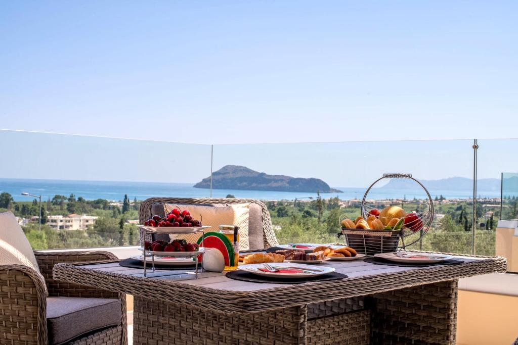 uma mesa com uma bandeja de comida numa varanda em Liberty & Freedom Luxury Villas em Platanias