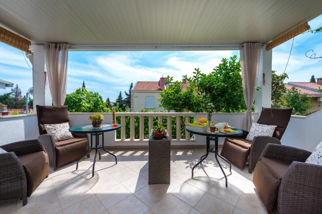 a patio with chairs and tables on a balcony at Guest House Kuna in Dubrovnik