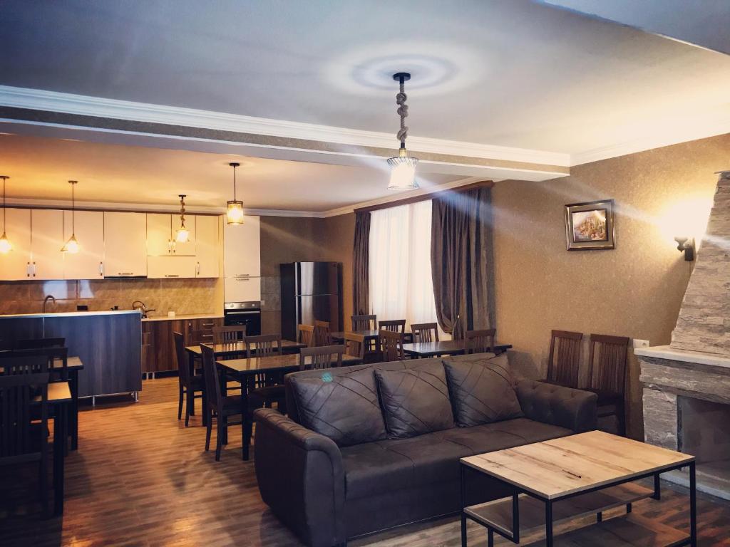 a living room with a couch and tables and a kitchen at Gudauri Hillsite in Gudauri