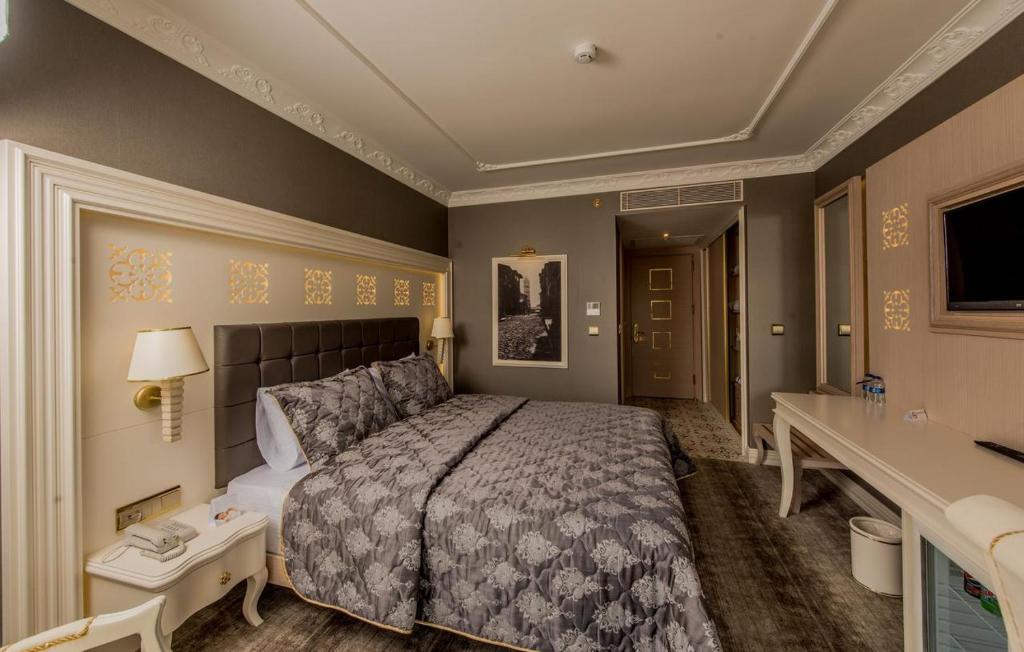 een slaapkamer met een bed, een bureau en een wastafel bij Altın Otel & Spa Balıkesir in Balıkesir