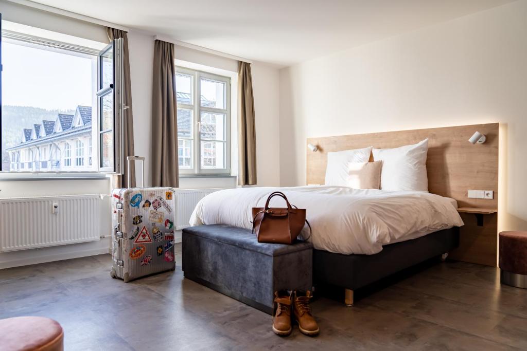 ein Hotelzimmer mit einem Bett und einem großen Fenster in der Unterkunft coucou hotel & kuckucks-stube (Titisee) in Titisee-Neustadt