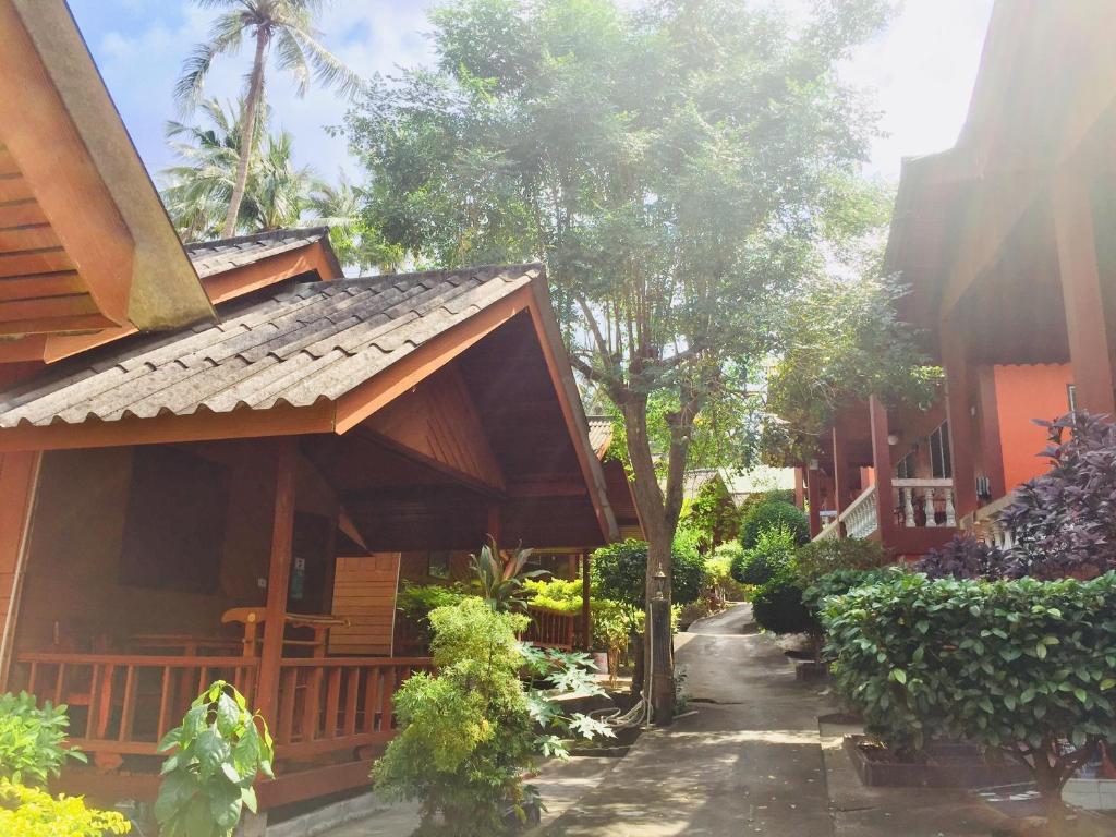 a house with a pathway next to a building at Save Bungalow Koh Tao in Koh Tao