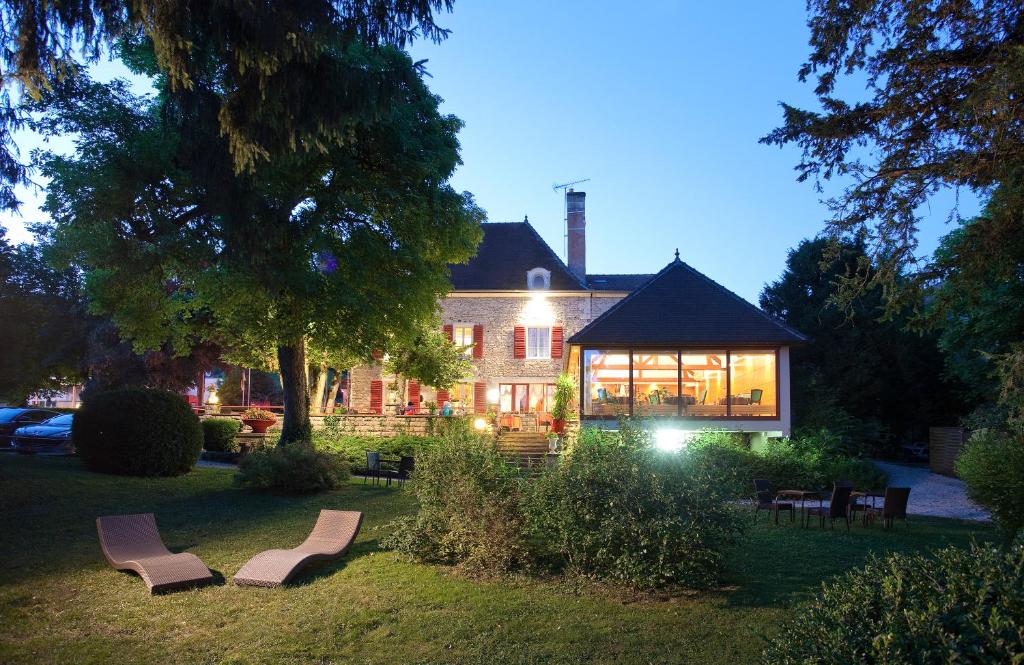 a house with a lot of chairs in front of it at Logis Hostellerie la Chaumière in Arsonval