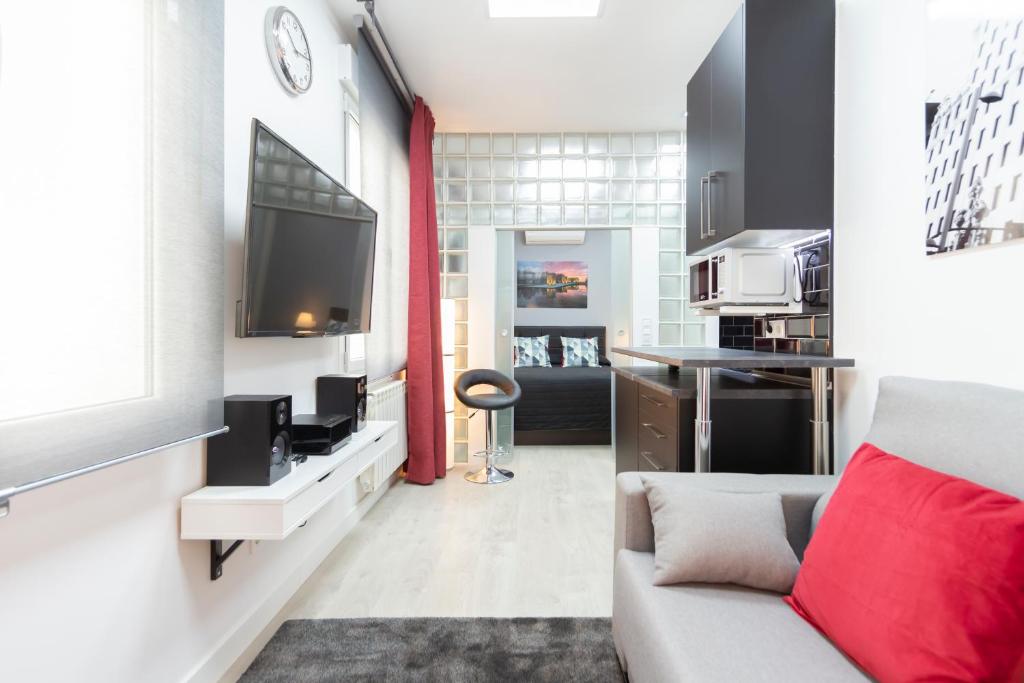 a living room with a couch and a tv at Gran Vía Apartment in Madrid