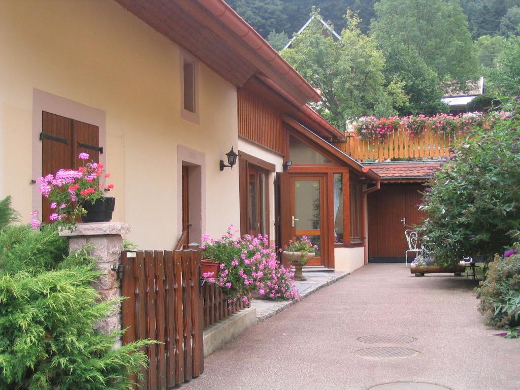 una casa con una valla y flores en ella en Les Gentianes, en Breitenbach-Haut-Rhin