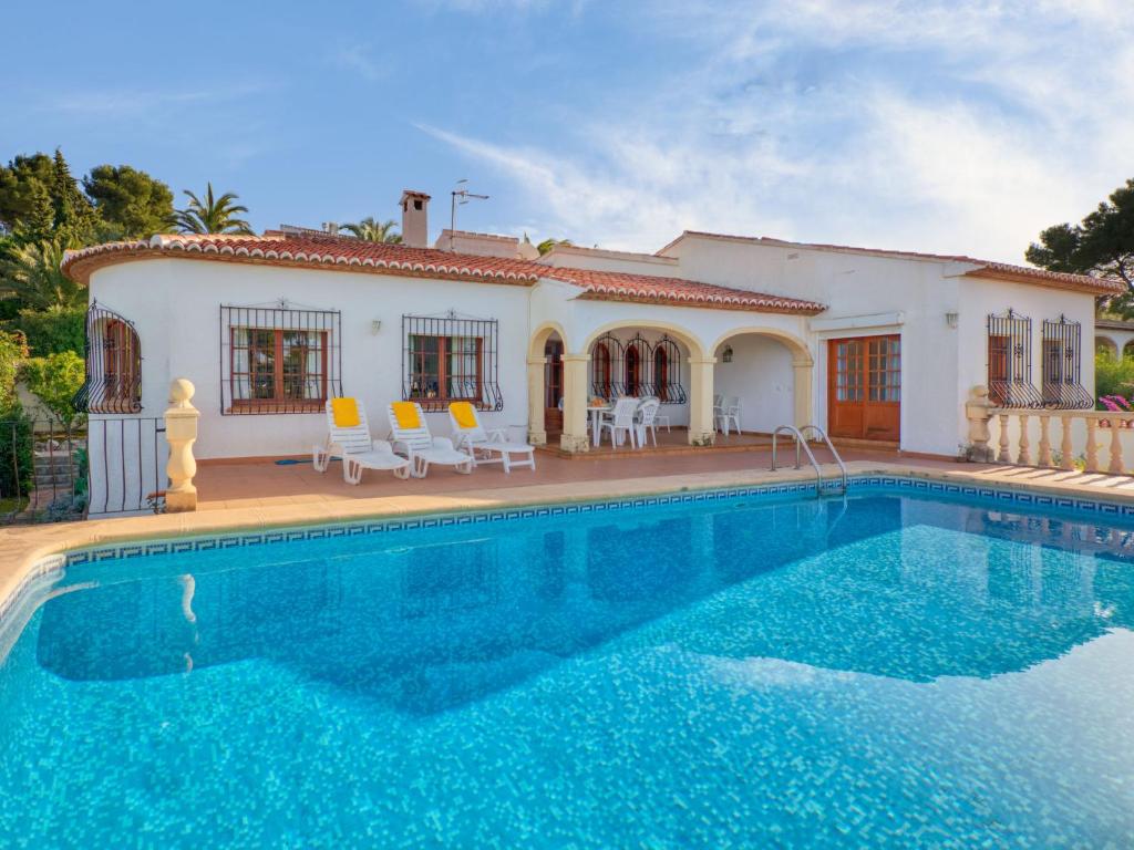 a villa with a swimming pool in front of a house at Holiday Home Cap Marti by Interhome in Balcon del Mar