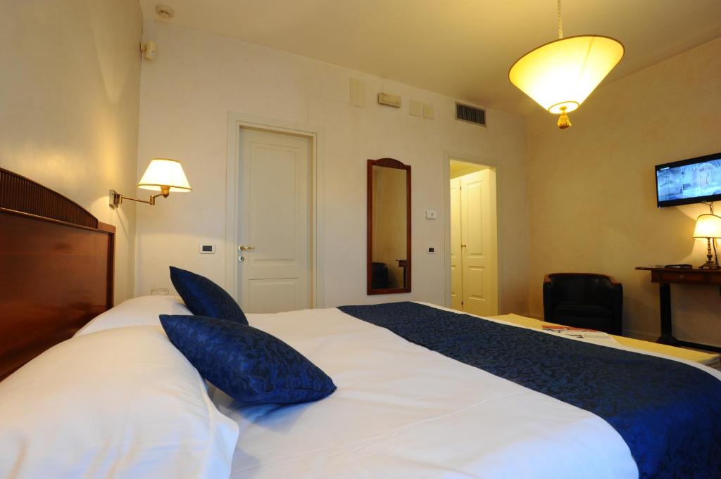 a bedroom with a large white bed with blue pillows at Locanda del Ghetto in Venice