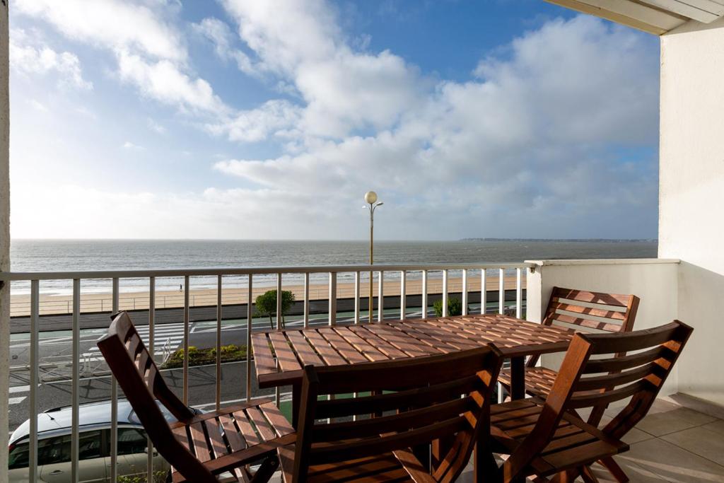 une table et des chaises sur un balcon avec vue sur l'océan dans l'établissement Un séjour ou un week-end face mer à la Baule, à La Baule