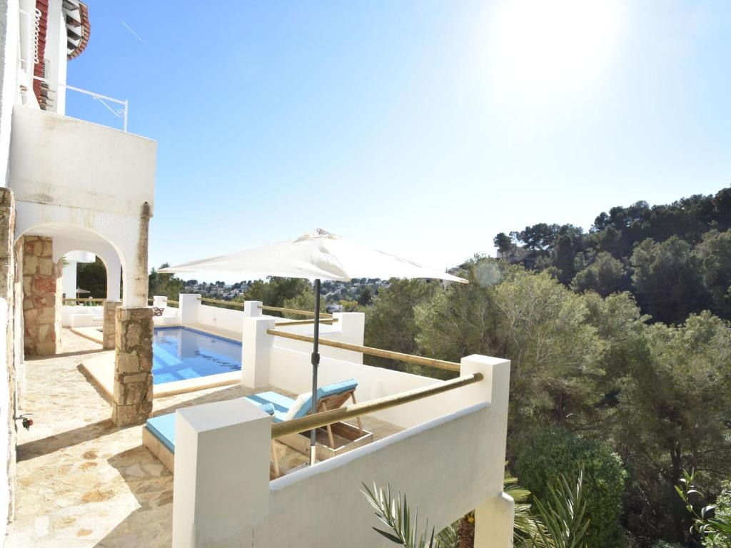 une villa blanche avec une piscine et un parasol dans l'établissement Belvilla by OYO Casa La Vida, à Benissa