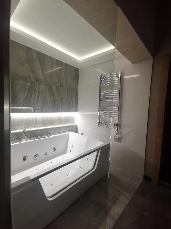 biała łazienka z dużą umywalką i lustrem w obiekcie Lux A28 w Nowym Sadzie