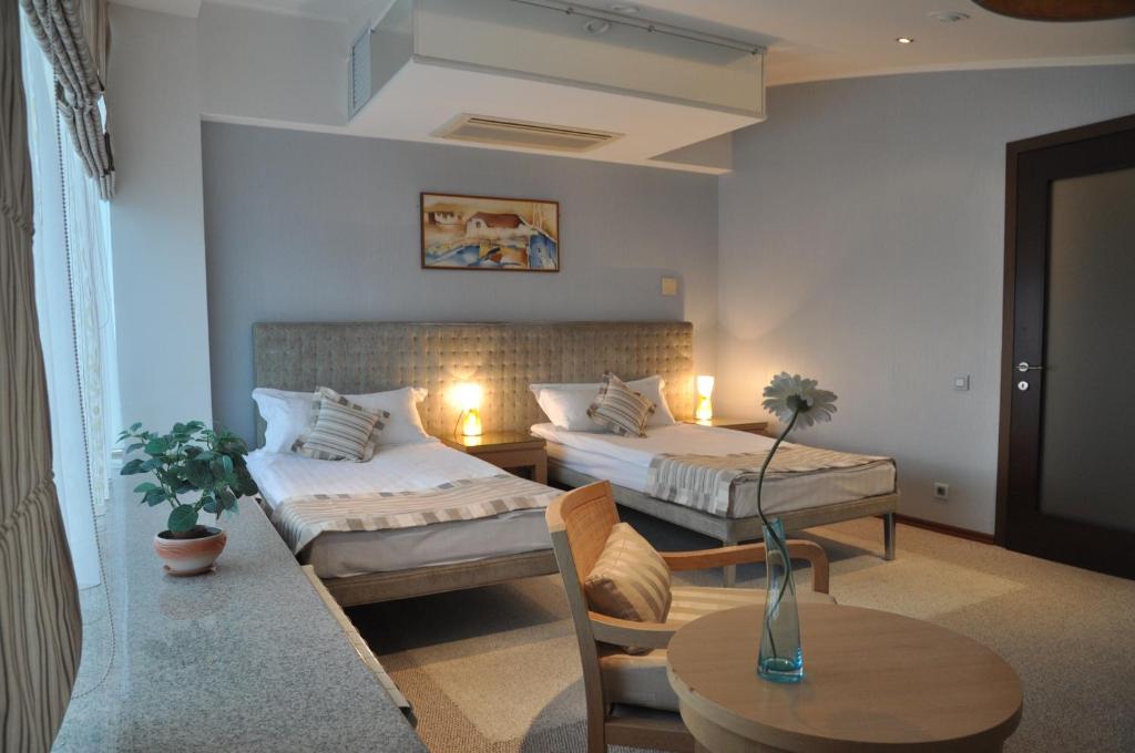 車里雅賓斯克的住宿－佩爾索納酒店，酒店客房设有两张床和一张桌子。