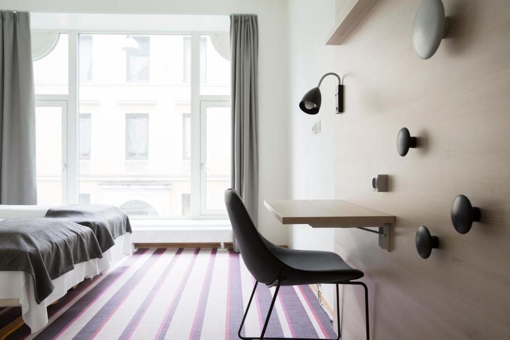 a bedroom with a desk and a chair in front of a window at Citybox Oslo in Oslo
