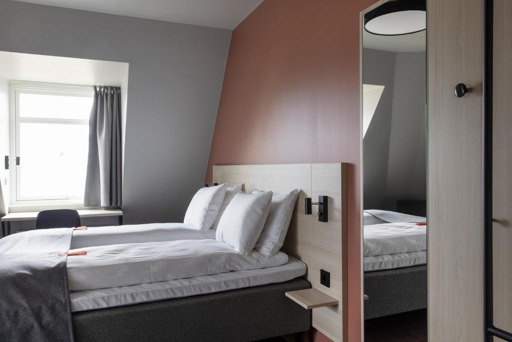a hotel room with two beds and a mirror at Citybox Oslo in Oslo