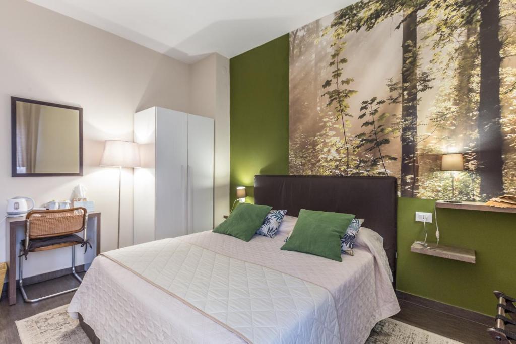a bedroom with a large bed with green walls at B&b Igea 50 in Modena