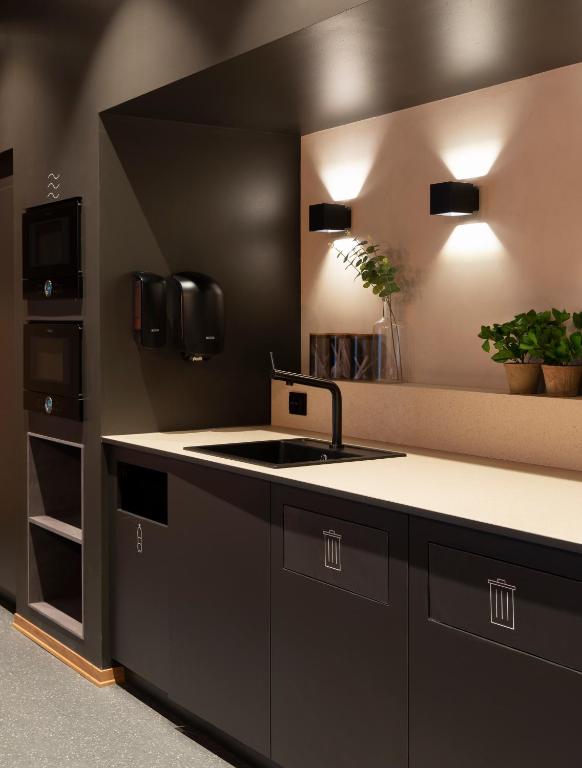a black kitchen with a sink and a counter at Citybox Oslo in Oslo