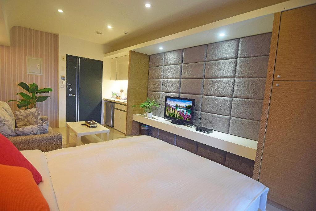 a hotel room with a bed and a tv on a wall at No. 21 Jiaoxi Hot Spring Homestay in Jiaoxi