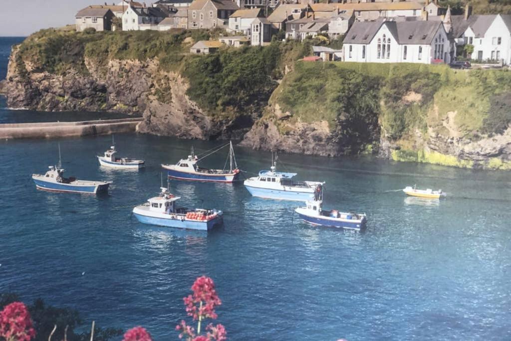 a group of boats in a body of water at Bay House Lobber Port Isaac Apartment with Sea Views in Port Isaac
