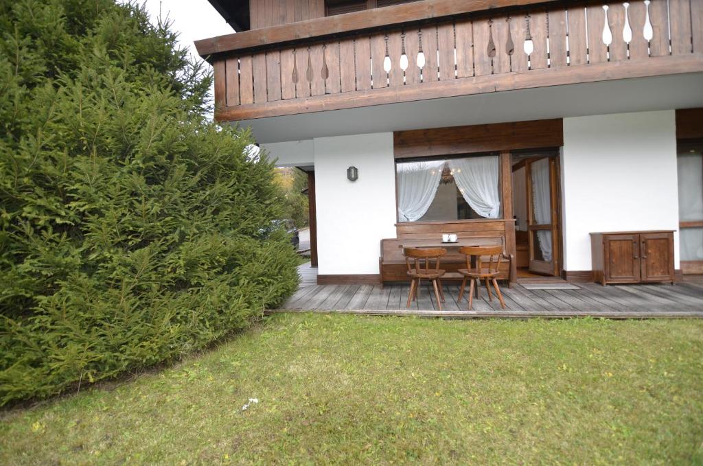 une terrasse en bois avec une table et des chaises sur une maison dans l'établissement Punta Nera: appartamento con giardino e WIFI, à Zuel