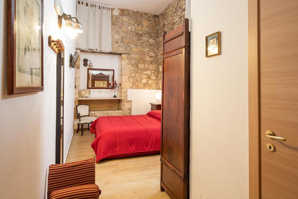 シラクーサにあるGli appartamenti di Locanda Nonna Ioleのベッドルーム1室(赤いベッド1台付)