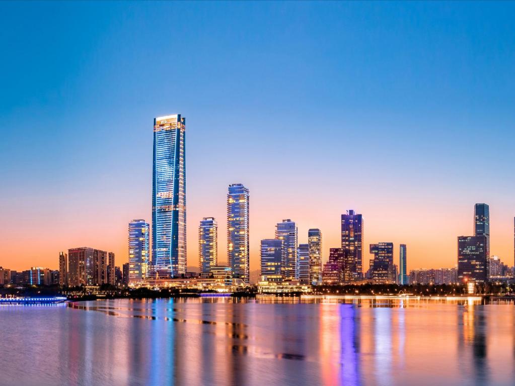 a view of a city skyline at sunset at Raffles Shenzhen, Enjoy the daily happy hour in Long Bar, complimentary mini bar and welcome amenities in Shenzhen