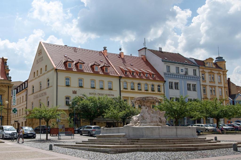 uma estátua no meio de uma cidade com edifícios em Hotel Česká Koruna em Děčín