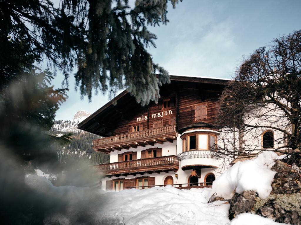 um grande edifício na neve em frente em B&B Mia Majon em Canazei