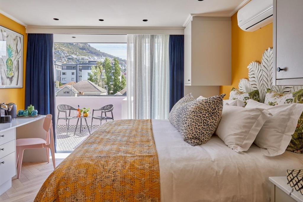a bedroom with a large bed with a large window at Pineapple House Boutique Hotel in Cape Town