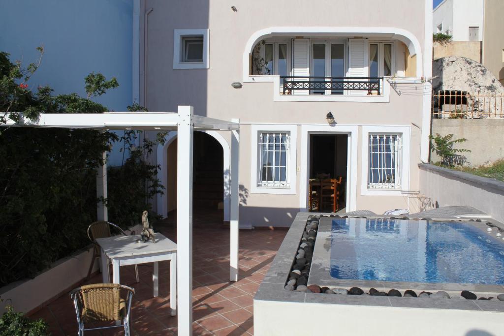 a house with a swimming pool next to a building at Villa by Hotel Thira in Fira
