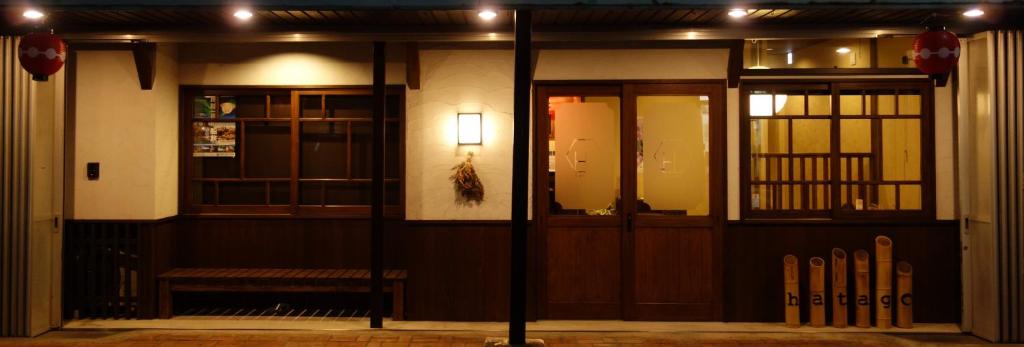 ein Gebäude mit einer Bank vor einer Tür in der Unterkunft Yanagawa B&B hatago in Yanagawa