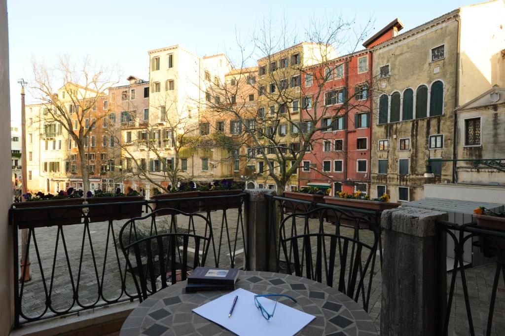 a table on a balcony with a view of buildings at Locanda del Ghetto in Venice