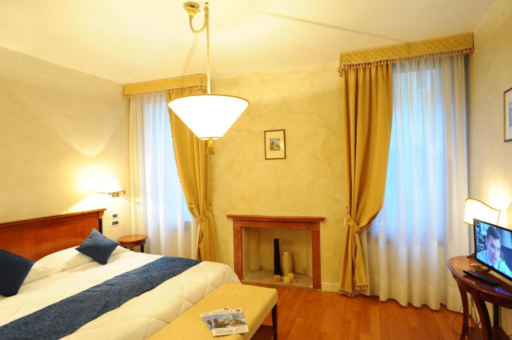 a hotel room with a bed and a fireplace at Locanda del Ghetto in Venice