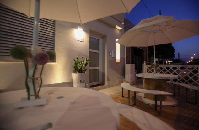 a patio with a table and an umbrella at Dimore di Mare in San Pietro Vernotico