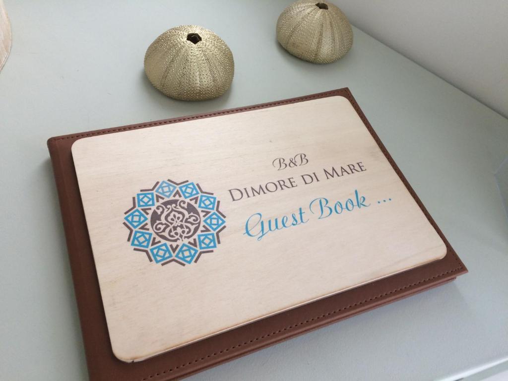 a sign on a wall with a guest book at Dimore di Mare in San Pietro Vernotico