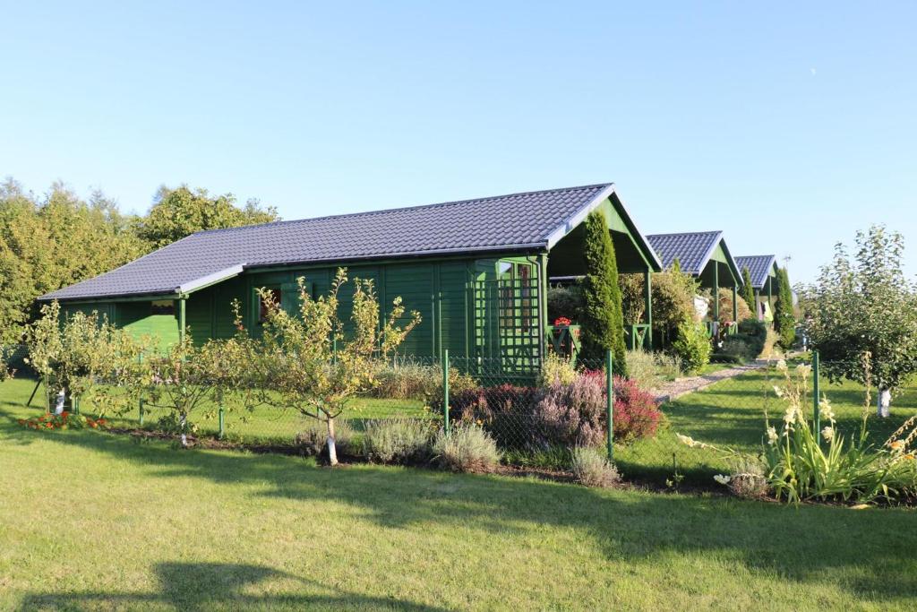 una casa con un jardín delante de ella en Domki Green Grzybowo en Grzybowo