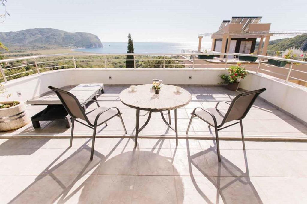 a patio with a table and chairs on a balcony at Mahakala Center in Petrovac na Moru