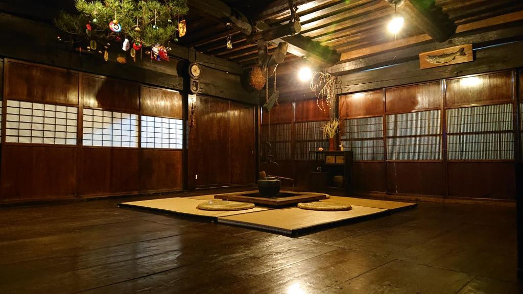 um quarto com um tapete no chão de um edifício em むかしの暮らし体験ー古民家の宿 みのり家 em Takayama