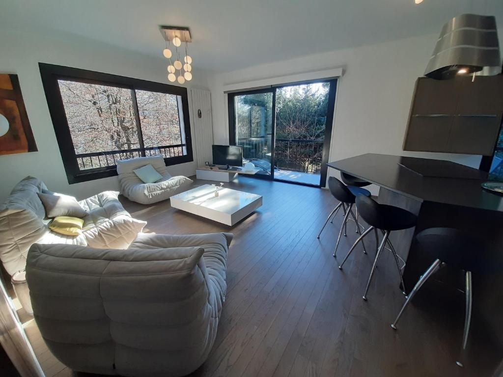 a living room with a couch and a table at Holiday home De la Corniche in Annecy