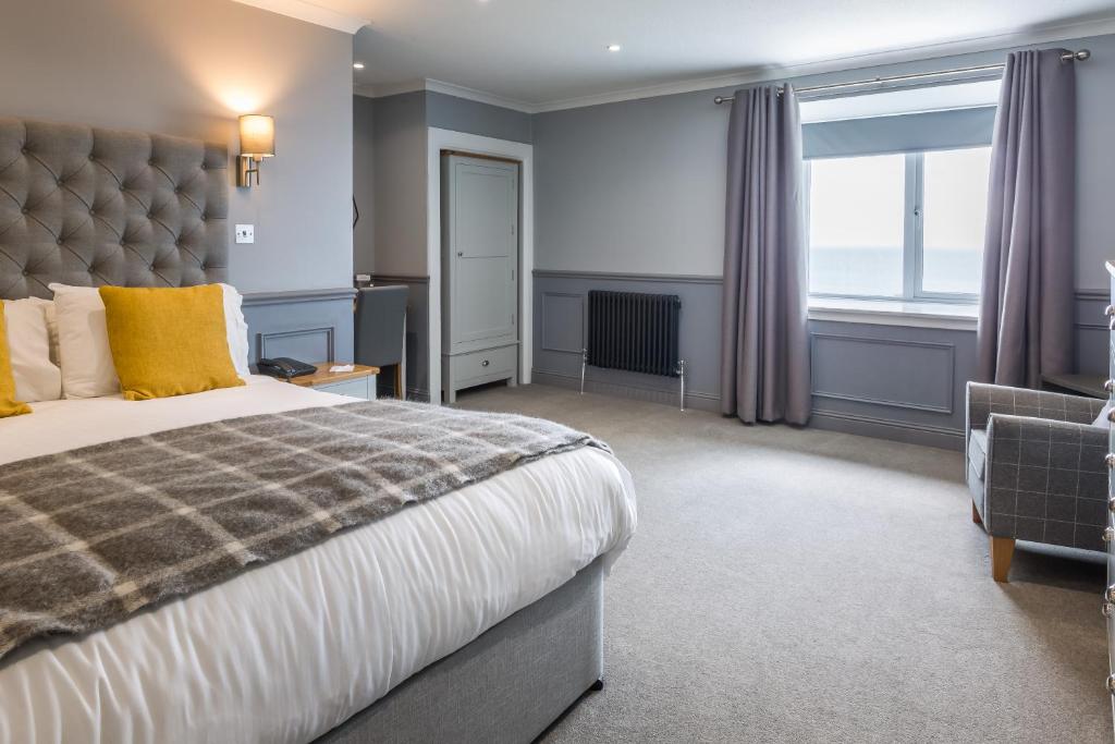 a bedroom with a large bed and a large window at Kinloch Hotel, Isle of Arran in Blackwaterfoot