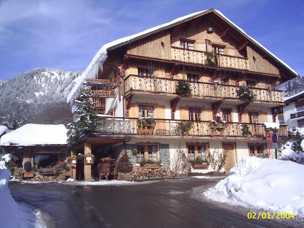 a large wooden building with snow on the ground at Les Chalets de La Griyotire in Praz-sur-Arly