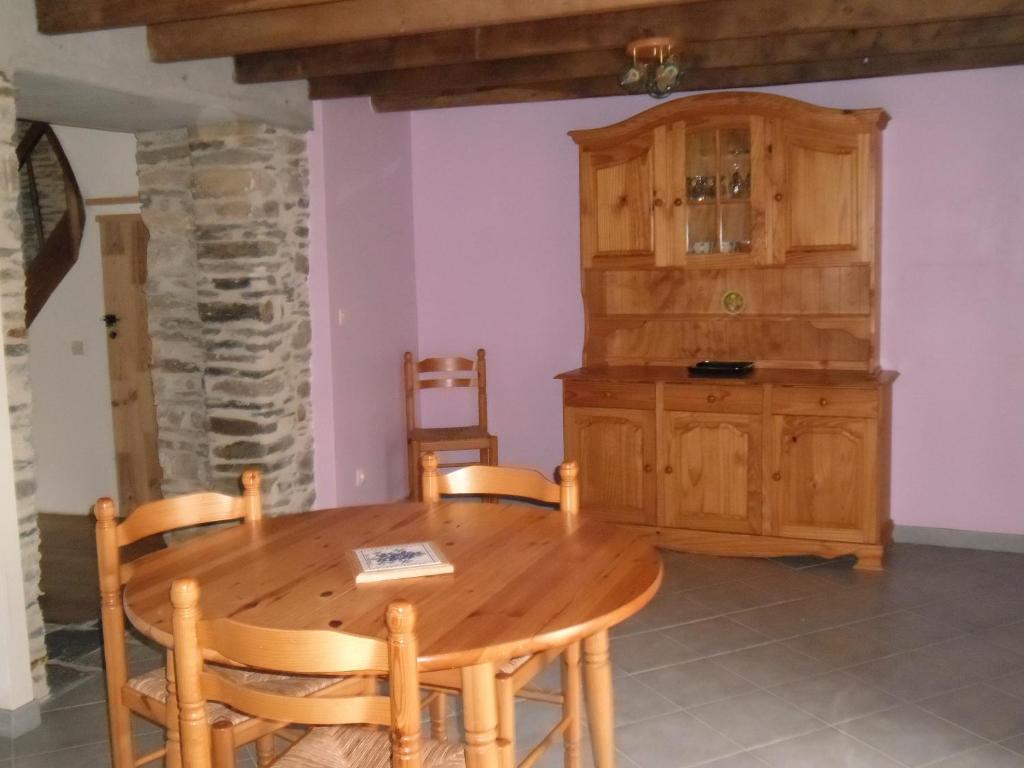 uma sala de jantar com uma mesa de madeira e armários em gite colorado em Renac
