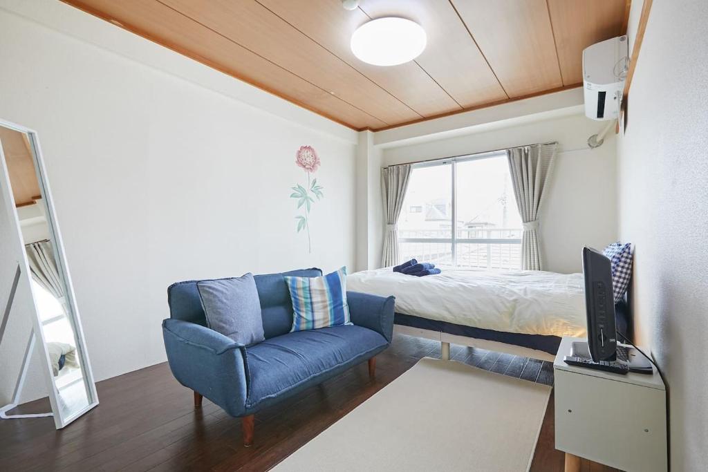 a small bedroom with a bed and a blue chair at Sun white Gyoutoku 202 in Urayasu