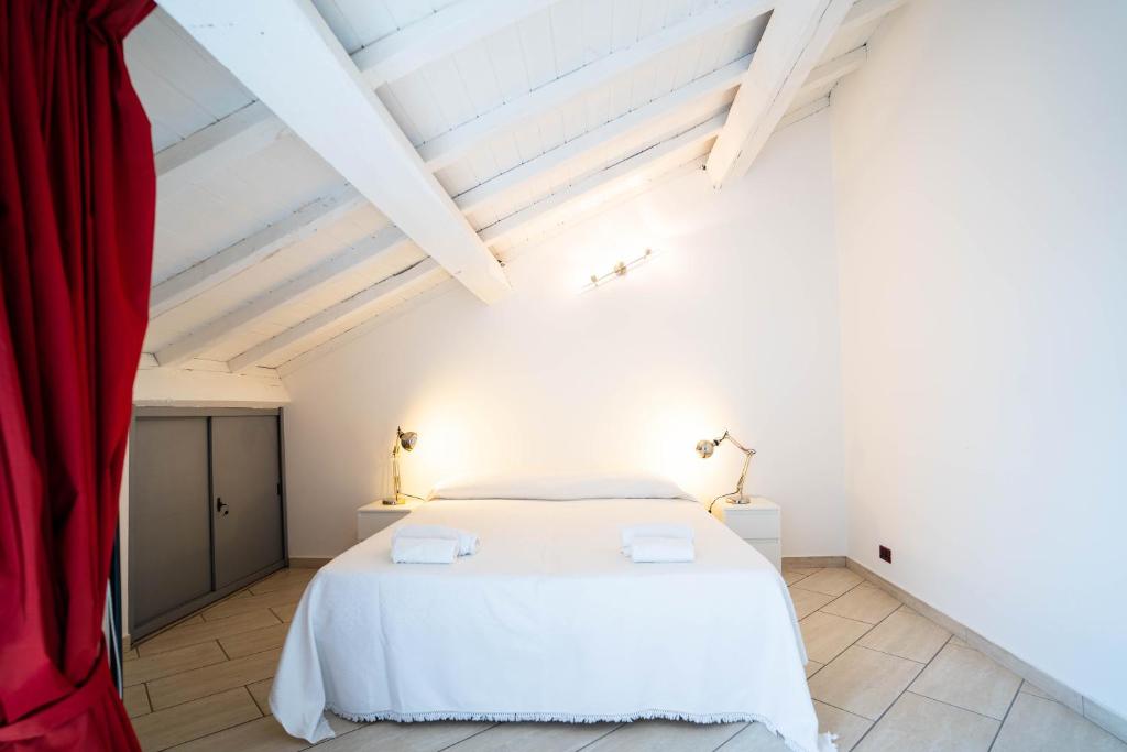 ein Schlafzimmer mit einem weißen Bett und einem roten Vorhang in der Unterkunft V12 Apartments - Vittoria 12 in Novara