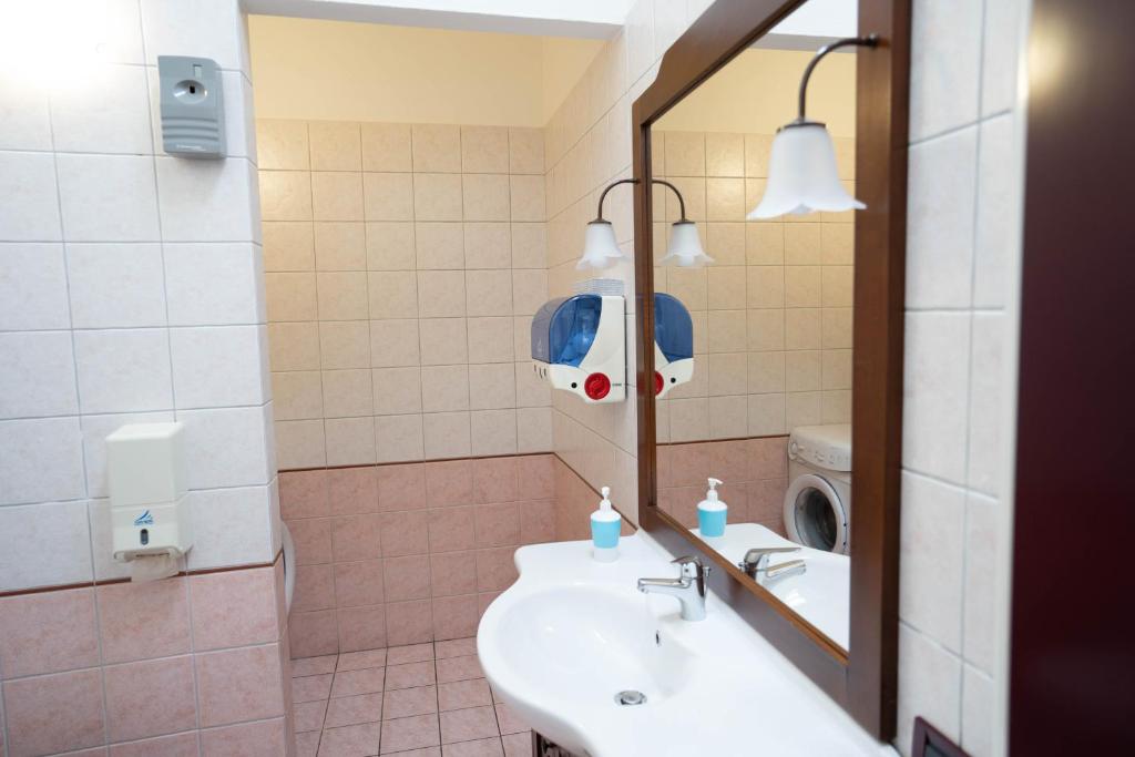 W łazience znajduje się umywalka, lustro i pralka. w obiekcie V12 Apartments - Vittoria 12 w mieście Novara
