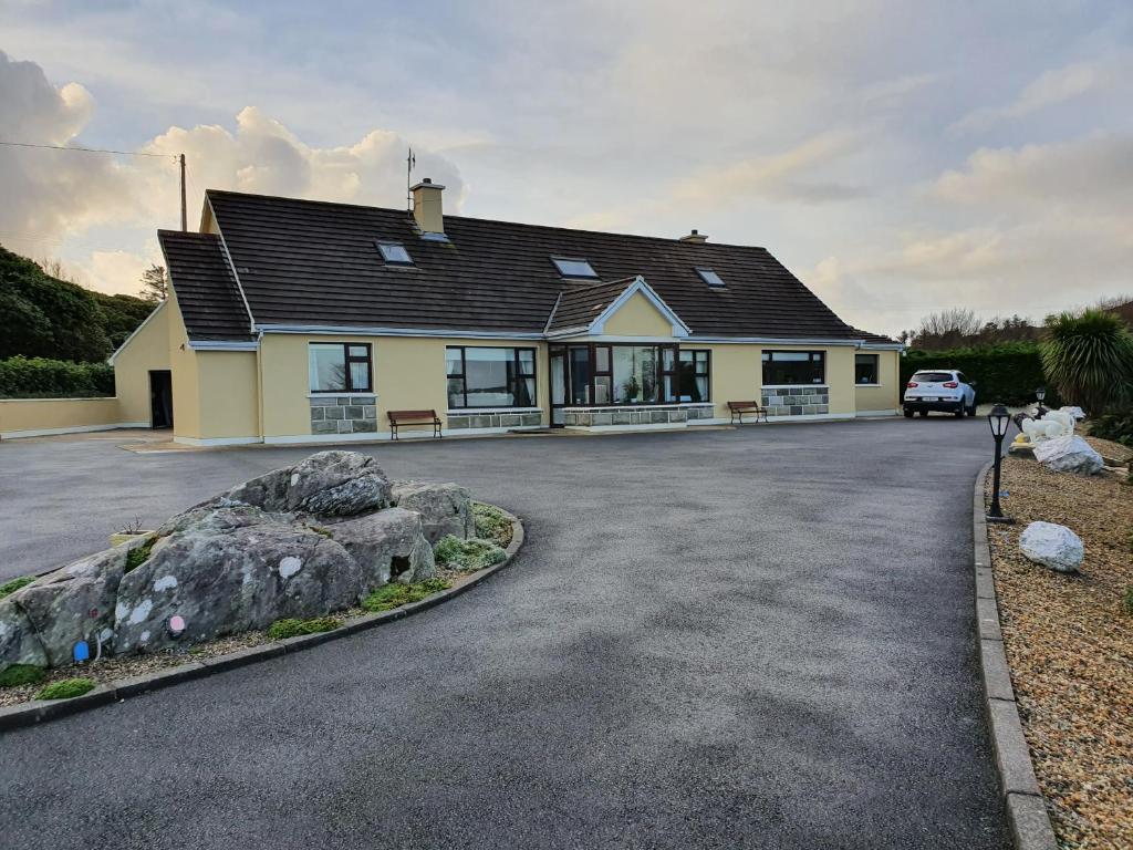 a house with a car parked in the driveway at Greystone House in Achill