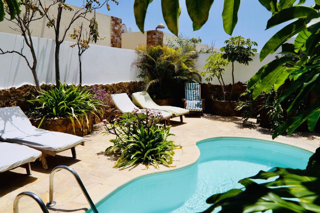 una piscina en un patio con sillas y plantas en Villa Beach Club, en Corralejo