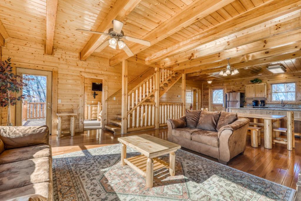 a living room with couches and a table in a log cabin at Papa Bears Cabin in Gatlinburg