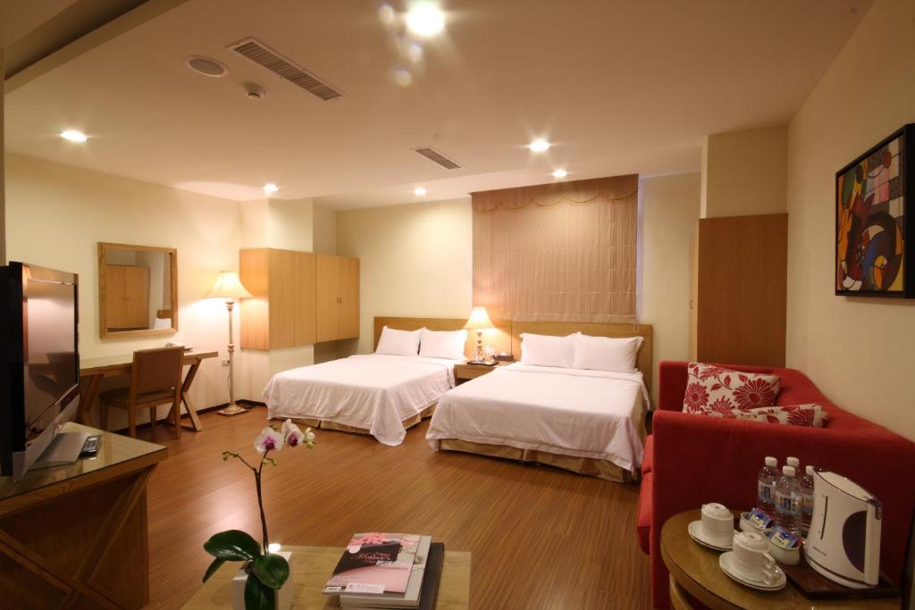 ein Hotelzimmer mit 2 Betten und einem Sofa in der Unterkunft 王牌旅館 Ace Hotel in Hualien