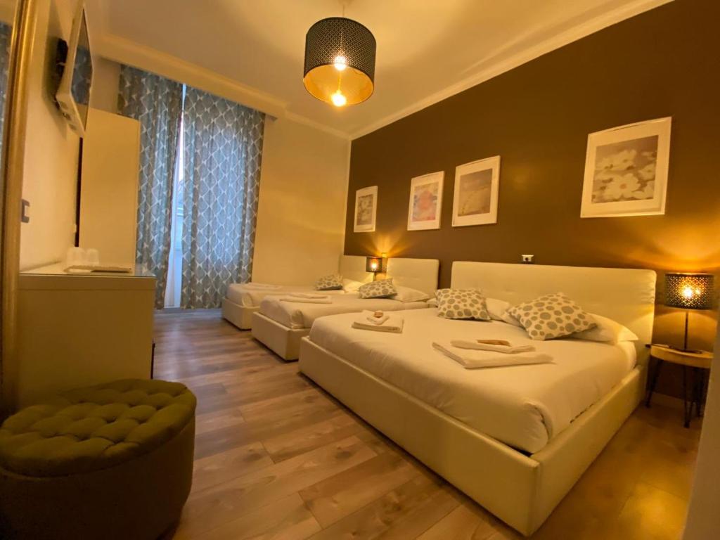 una camera d'albergo con due letti e un divano di The Place In Rome Guest House a Roma